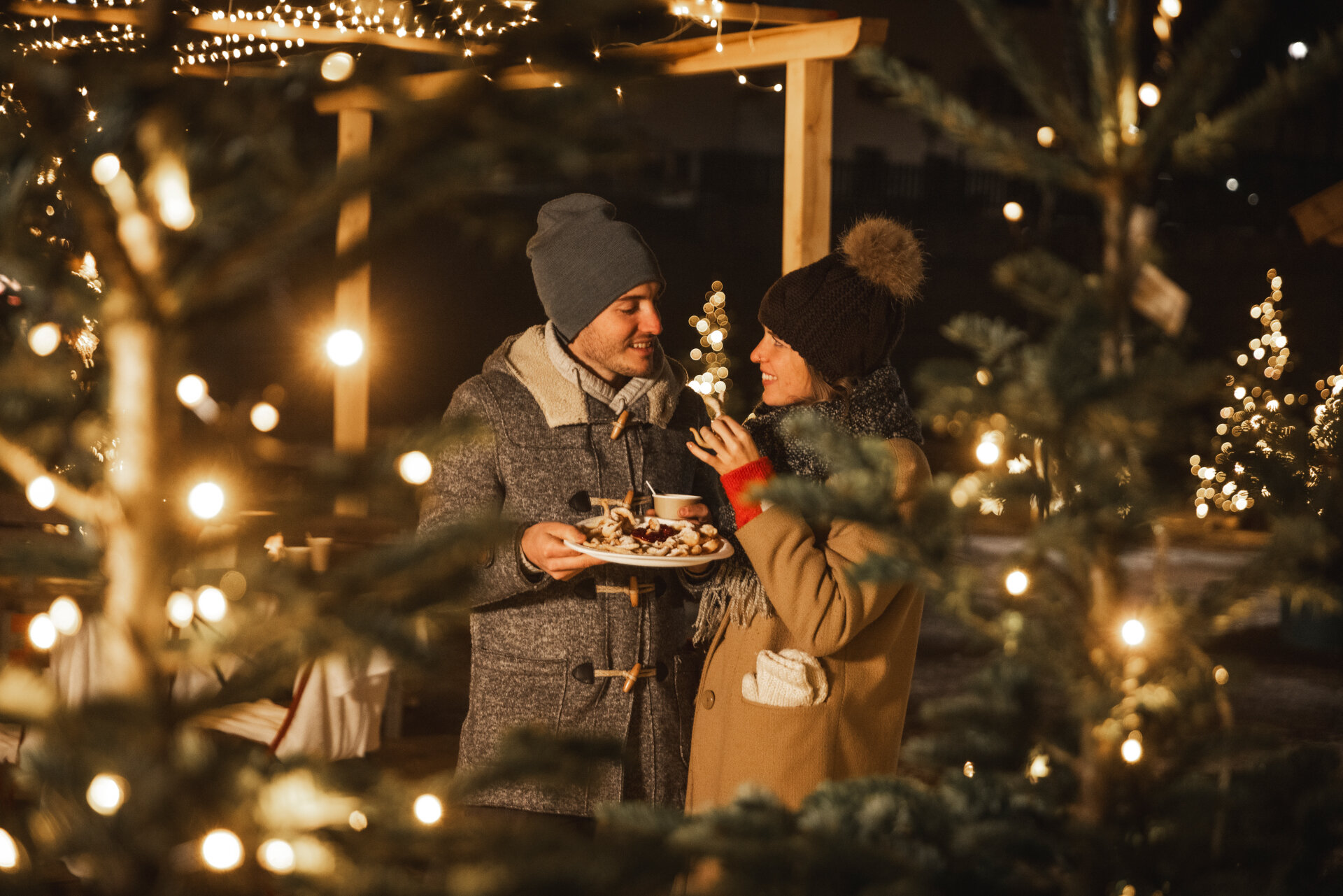Coppia fortae mercatini di natale | © Federico Modica - Archivio Immagini ApT Val di Fassa Coppia assaggia i dolci tipici della Val di Fassa nei mercatini di Natale | © Federico Modica - Archivio Immagini ApT Val di Fassa