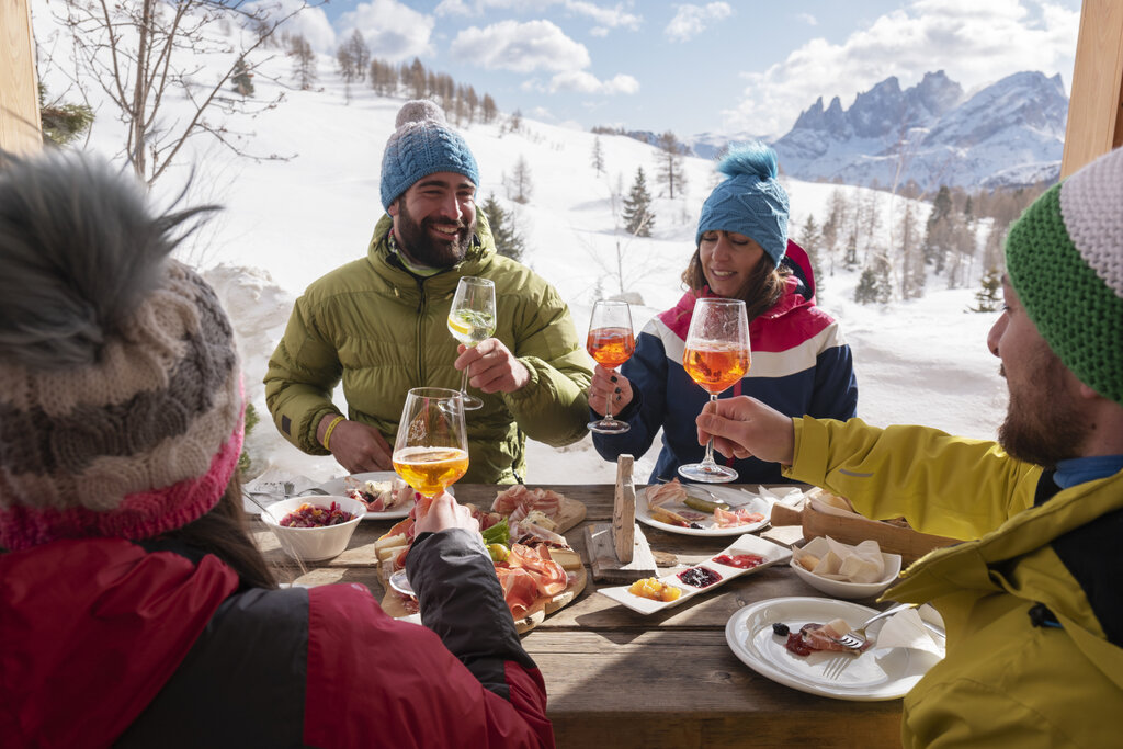 Aperitivo in un rifugio fra amici Gruppo di amici fa aperitivo in un rifugio