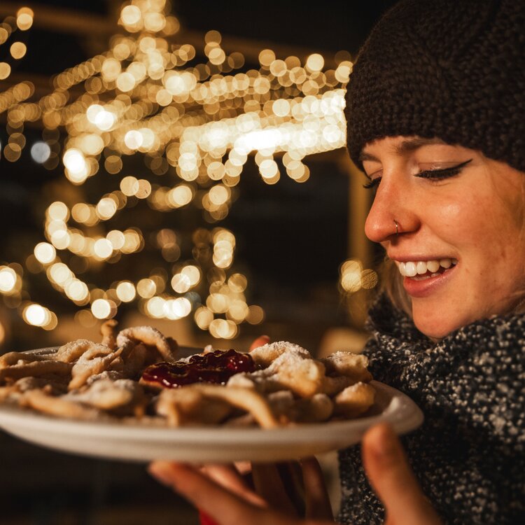 Dolci tipici ai mercatini di Natale | © Federico Modica - Archivio Immagini Val di Fassa Ragazza assaggia le fortae | © Federico Modica - Archivio Immagini Val di Fassa