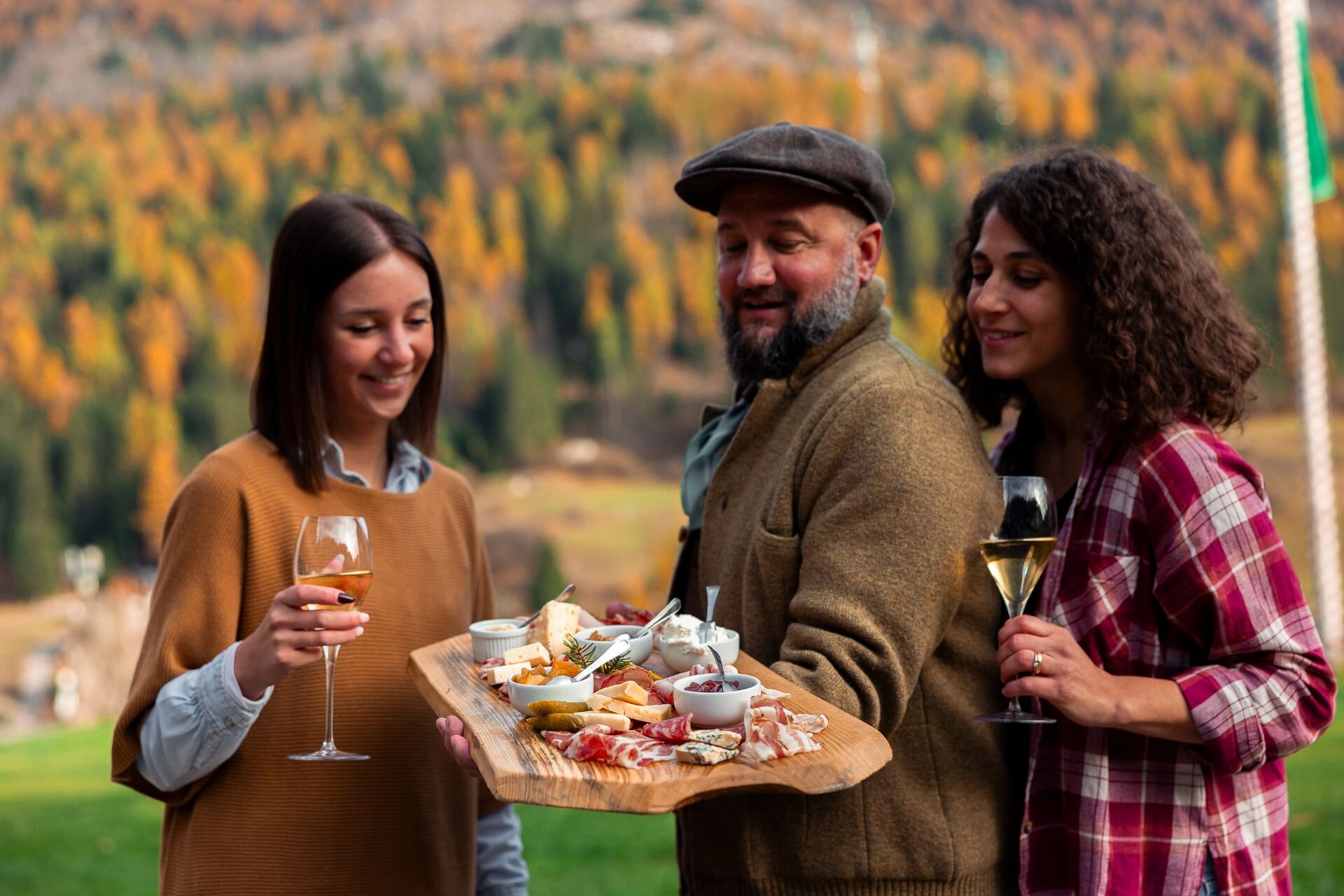 Mangiare e bere in Val di Fassa in autunno | © Archivio Immagini ApT Val di Fassa - Federico Modica  Gruppo di persone assaggia un tagliere di prodotti tipici autunnali della val di Fassa | © Archivio Immagini ApT Val di Fassa - Federico Modica